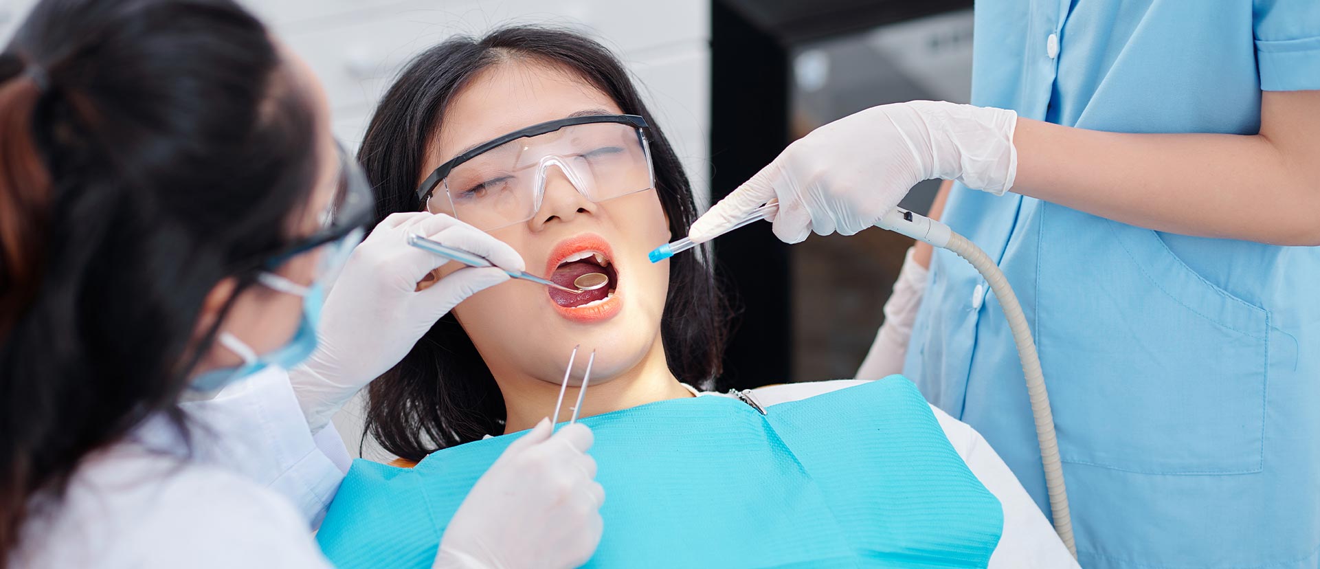 A woman is having tooth extraction at the dental